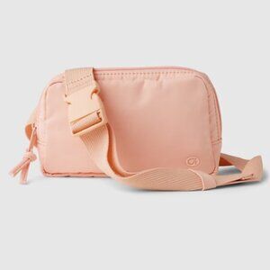 - GapFit 100% Recycled Belt Bag in featured Powder Peach color